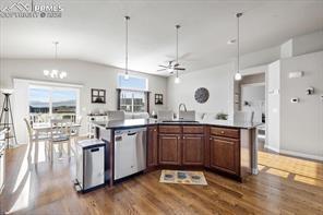 10150 Bracknell Pl, Peyton, CO 80831 - kitchen featuring stainless steel dishwasher, dark wood-style flooring, ceiling fan, a sink, and a kitchen island with sink