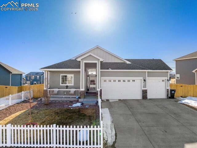 10150 Bracknell Pl, Peyton, CO 80831 - ranch-style home featuring a garage, driveway, covered porch, board and batten siding, and stone siding