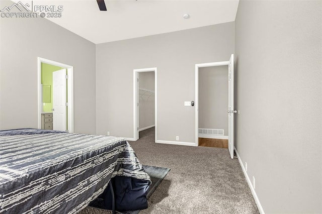12383 Pine Valley Cir, Peyton, CO 80831 - carpeted bedroom featuring a walk in closet, ensuite bathroom, baseboards, and a ceiling fan