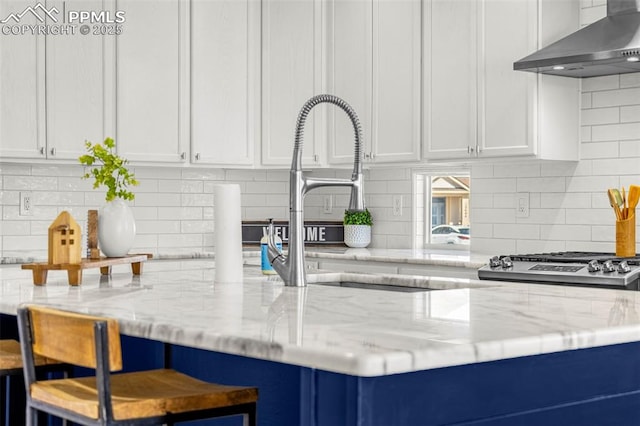 12383 Pine Valley Cir, Peyton, CO 80831 - kitchen featuring wall chimney range hood, white cabinetry, and tasteful backsplash