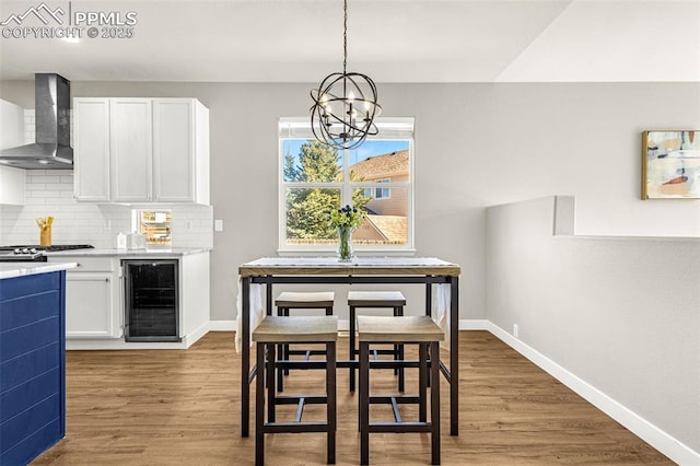 12383 Pine Valley Cir, Peyton, CO 80831 - dining space featuring wine cooler, a chandelier, light wood-style floors, and baseboards