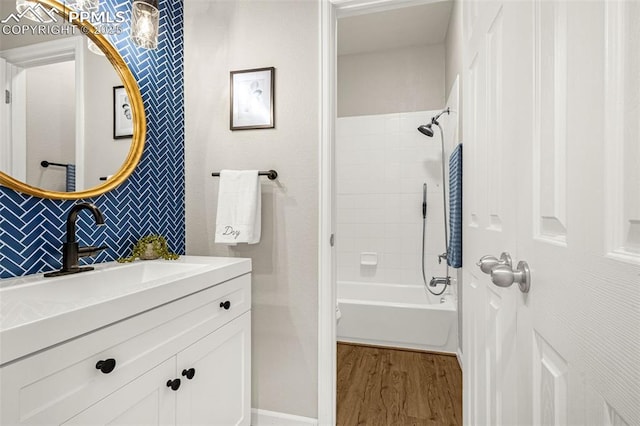 12383 Pine Valley Cir, Peyton, CO 80831 - bathroom with wood finished floors, vanity, decorative backsplash, shower / tub combination, and baseboards