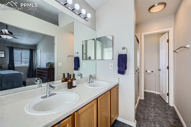 6640 Oakwood Blvd, Colorado Springs, CO 80923 - bathroom with ceiling fan, baseboards, double vanity, tile patterned flooring, and a textured ceiling