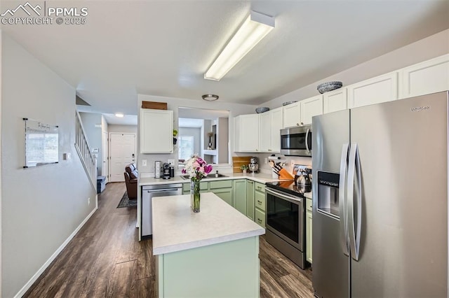 6640 Oakwood Blvd, Colorado Springs, CO 80923 - kitchen with stainless steel appliances, a kitchen island, white cabinetry, dark wood-type flooring, and light countertops