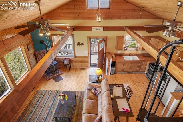 18 Fountain Pl, Manitou Springs, CO 80829 - living area featuring a ceiling fan, wooden walls, light wood-style floors, a wainscoted wall, and high vaulted ceiling