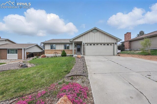 5050 Bunk House Ln, Colorado Springs, CO 80917 - ranch-style home featuring board and batten siding, an attached garage, a front lawn, concrete driveway, and brick siding