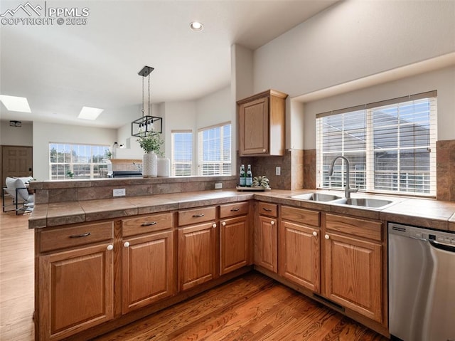 7049 Vasalias Hts, Colorado Springs, CO 80923 - kitchen featuring a sink, a peninsula, light wood-style flooring, and dishwasher