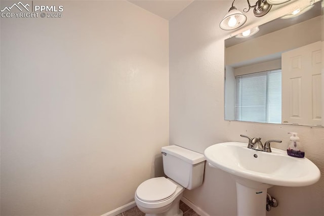 bathroom featuring toilet and baseboards