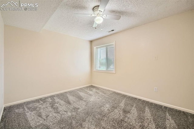 empty room featuring a ceiling fan, a textured ceiling, baseboards, visible vents, and carpet floors