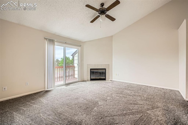 unfurnished living room with a textured ceiling, carpet, ceiling fan, vaulted ceiling, and a tile fireplace