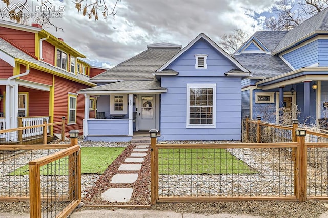 2005 W Colorado Ave, Colorado Springs, CO 80904 - view of front of property featuring a front lawn, roof with shingles, a fenced front yard, and covered porch