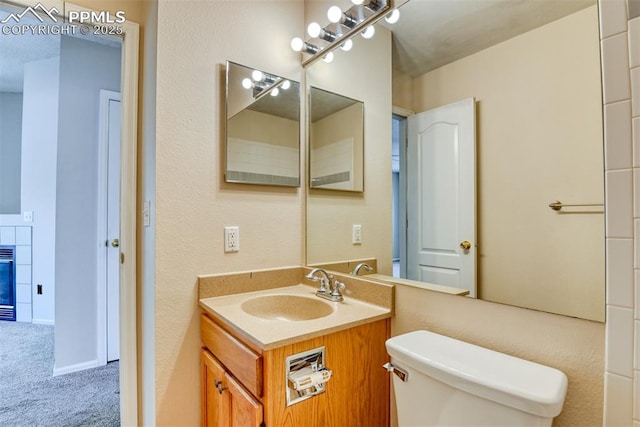 2610 Plumtree Grv, Colorado Springs, CO 80907 - bathroom featuring toilet, vanity, and a tile fireplace