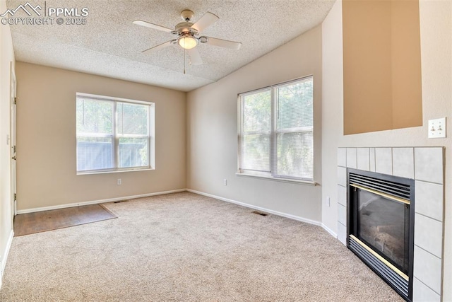 2610 Plumtree Grv, Colorado Springs, CO 80907 - unfurnished living room with a textured ceiling, healthy amount of natural light, carpet, a tile fireplace, and ceiling fan