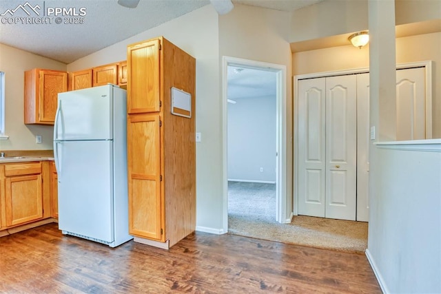 2610 Plumtree Grv, Colorado Springs, CO 80907 - kitchen featuring freestanding refrigerator, lofted ceiling, wood finished floors, light countertops, and baseboards