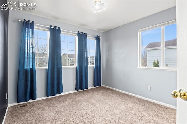 unfurnished room with carpet flooring, plenty of natural light, visible vents, and baseboards
