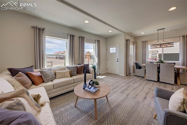 living area featuring light wood-style floors, recessed lighting, baseboards, and a healthy amount of sunlight