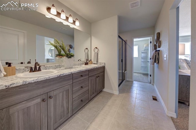 bathroom with a sink, a stall shower, double vanity, and visible vents