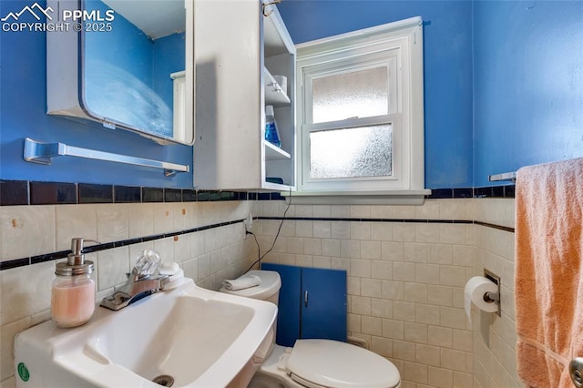 1416 N Foote Ave, Colorado Springs, CO 80909 - bathroom with tile walls, a sink, toilet, and wainscoting