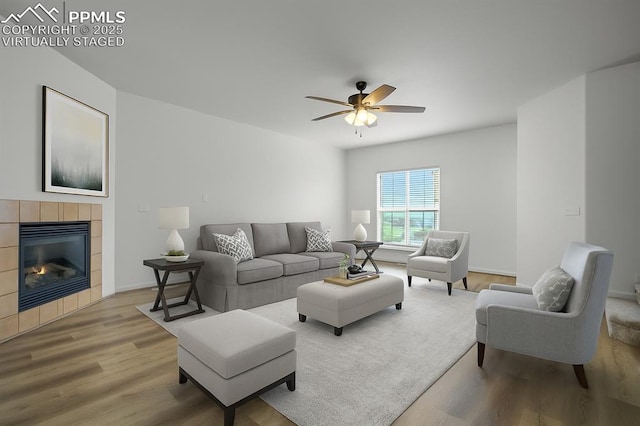 1118 Walters Pt, Monument, CO 80132 - living area featuring light wood-type flooring, a ceiling fan, and a tiled fireplace