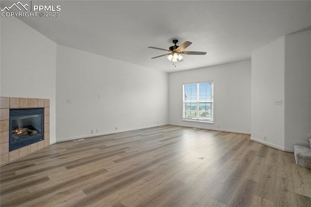 1118 Walters Pt, Monument, CO 80132 - unfurnished living room featuring a ceiling fan, wood finished floors, and a fireplace