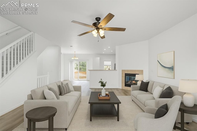 1118 Walters Pt, Monument, CO 80132 - living area with wood finished floors, a ceiling fan, stairway, a tiled fireplace, and recessed lighting