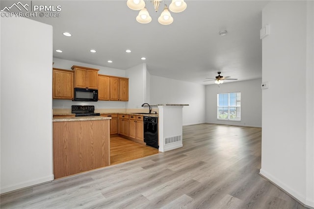 1118 Walters Pt, Monument, CO 80132 - kitchen with black appliances, a peninsula, open floor plan, recessed lighting, and a chandelier
