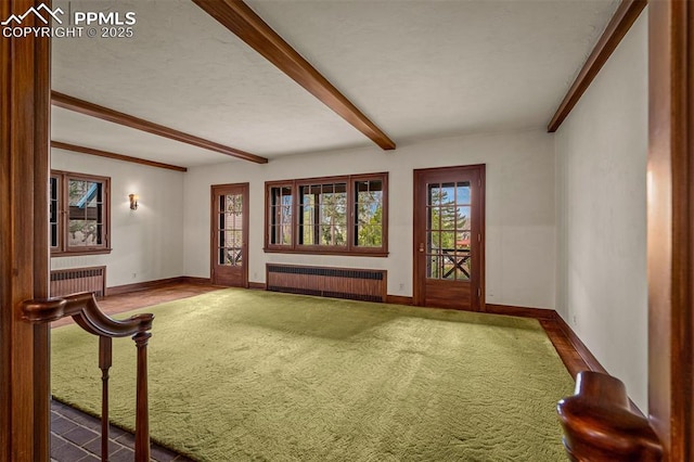 2126 Wood Ave, Colorado Springs, CO 80907 - unfurnished living room featuring radiator heating unit, carpet floors, baseboards, and beam ceiling