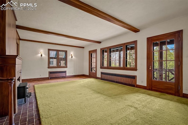 2126 Wood Ave, Colorado Springs, CO 80907 - unfurnished living room with radiator heating unit, beam ceiling, baseboards, and a wood stove