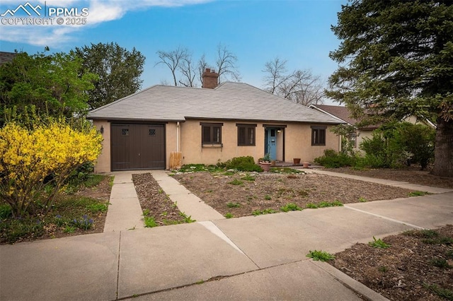 2126 Wood Ave, Colorado Springs, CO 80907 - view of front facade with a chimney, stucco siding, and concrete driveway
