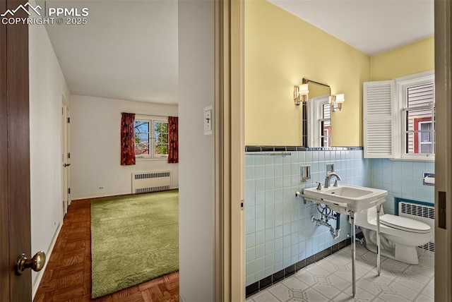 2126 Wood Ave, Colorado Springs, CO 80907 - half bath featuring radiator heating unit, tile walls, toilet, and a wainscoted wall