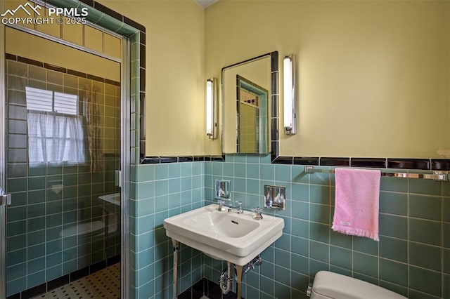 2126 Wood Ave, Colorado Springs, CO 80907 - bathroom with toilet, a shower stall, tile walls, and a sink