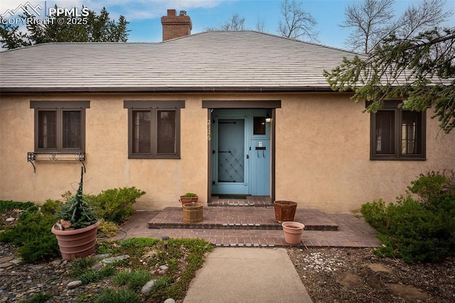 2126 Wood Ave, Colorado Springs, CO 80907 - property entrance featuring a chimney and stucco siding