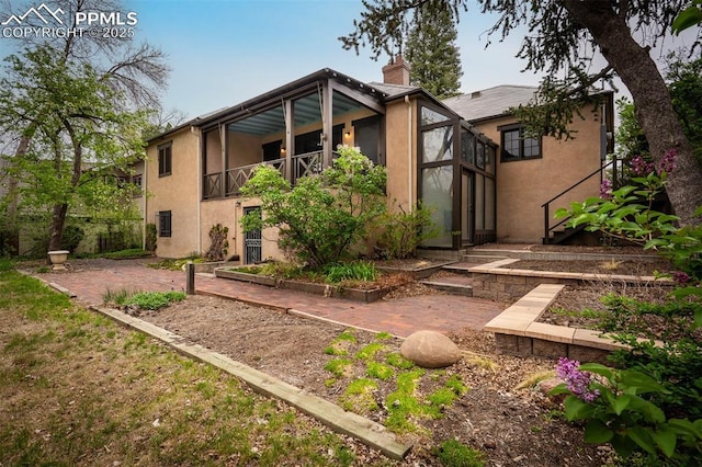 2126 Wood Ave, Colorado Springs, CO 80907 - rear view of house with stucco siding, a chimney, and a patio area