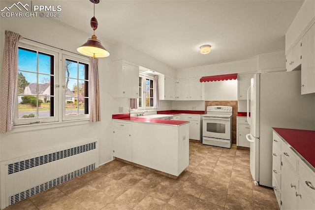 2126 Wood Ave, Colorado Springs, CO 80907 - kitchen featuring white appliances, radiator, a peninsula, a sink, and white cabinets