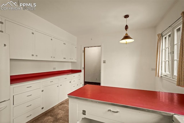 2126 Wood Ave, Colorado Springs, CO 80907 - kitchen with white cabinetry, pendant lighting, dark countertops, and dark tile patterned flooring