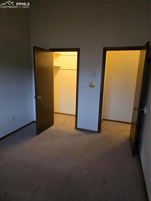 unfurnished bedroom featuring carpet flooring and baseboards
