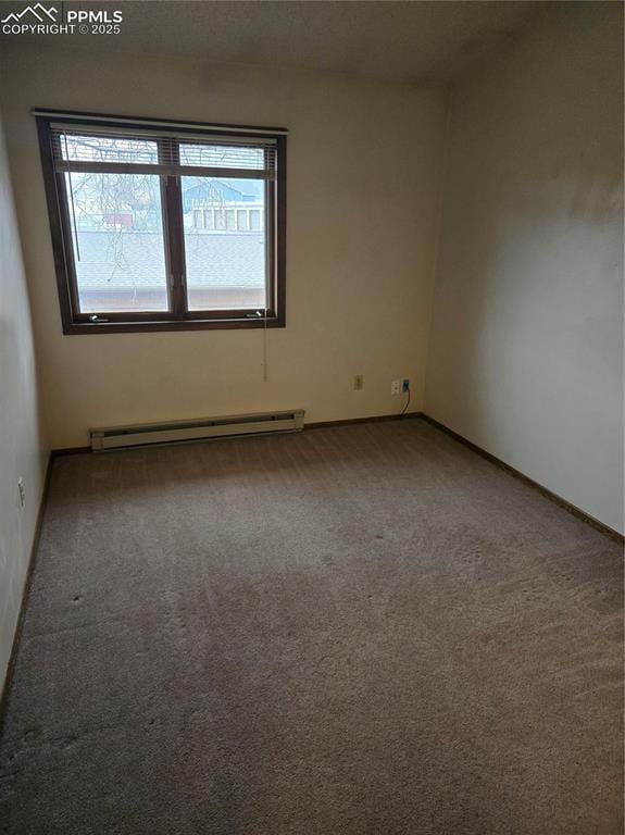 carpeted spare room with baseboards and a baseboard radiator