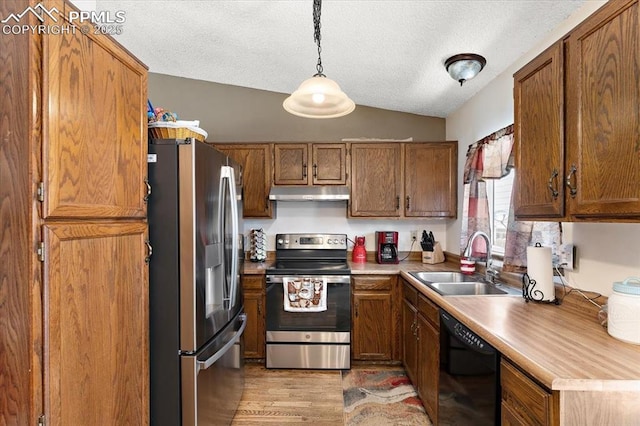 3425 Post Oak Dr, Colorado Springs, CO 80916 - kitchen featuring appliances with stainless steel finishes, a sink, under cabinet range hood, brown cabinetry, and a textured ceiling