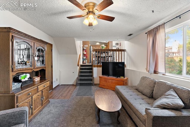 3425 Post Oak Dr, Colorado Springs, CO 80916 - living room featuring a textured ceiling, stairs, ceiling fan, and carpet flooring