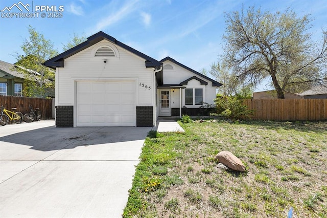 ranch-style home with concrete driveway, brick siding, fence, and an attached garage