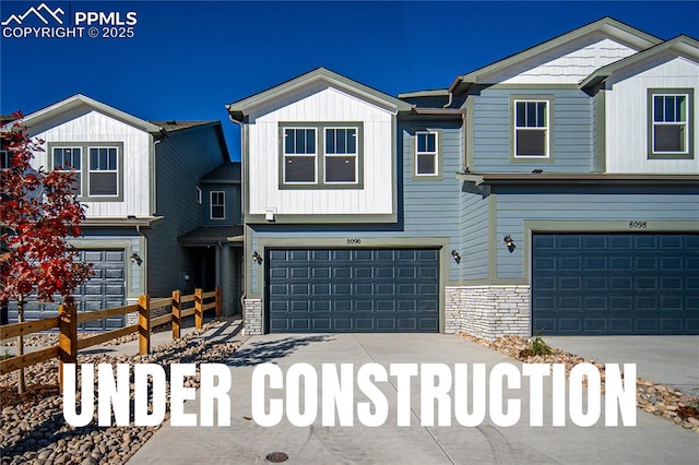 view of front of property featuring concrete driveway, fence, a garage, and stone siding