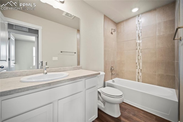 full bath featuring toilet, visible vents, vanity, shower / washtub combination, and wood finished floors