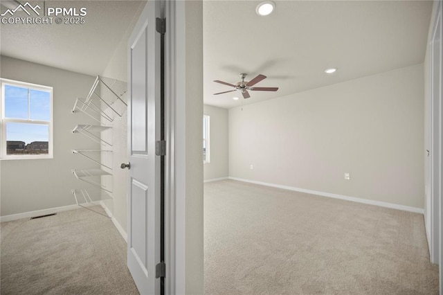 interior space featuring visible vents, ceiling fan, and carpet floors