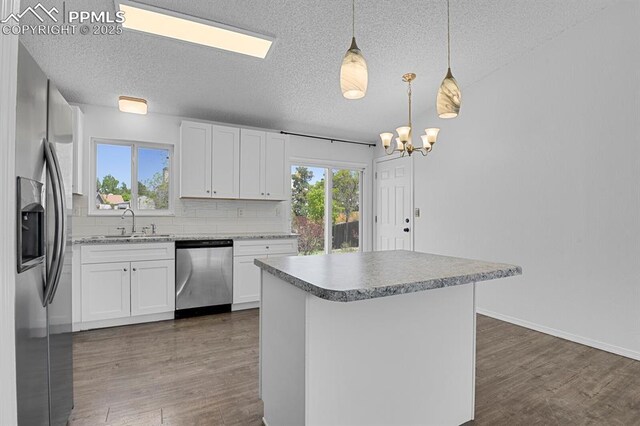 7920 Conifer Dr, Colorado Springs, CO 80920 - kitchen with stainless steel appliances, a textured ceiling, dark wood finished floors, a sink, and a chandelier