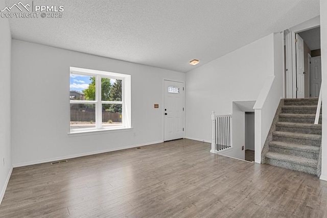7920 Conifer Dr, Colorado Springs, CO 80920 - foyer entrance with wood finished floors, a textured ceiling, stairway, and baseboards