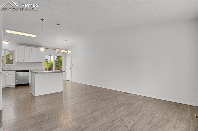 7920 Conifer Dr, Colorado Springs, CO 80920 - kitchen with stainless steel dishwasher, a chandelier, wood finished floors, white cabinets, and open floor plan