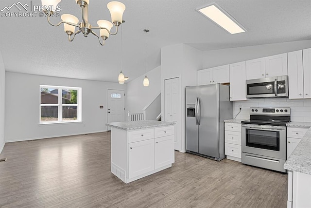 7920 Conifer Dr, Colorado Springs, CO 80920 - kitchen featuring stainless steel appliances, vaulted ceiling, a chandelier, light wood-style floors, and tasteful backsplash