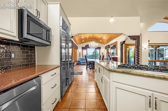 17995 Minglewood Trl, Monument, CO 80132 - kitchen featuring appliances with stainless steel finishes, lofted ceiling, light tile patterned floors, plenty of natural light, and a chandelier