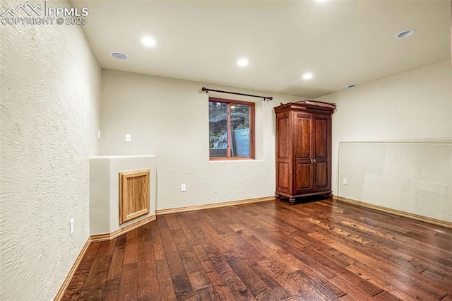 17995 Minglewood Trl, Monument, CO 80132 - spare room with dark wood finished floors, a textured wall, and recessed lighting