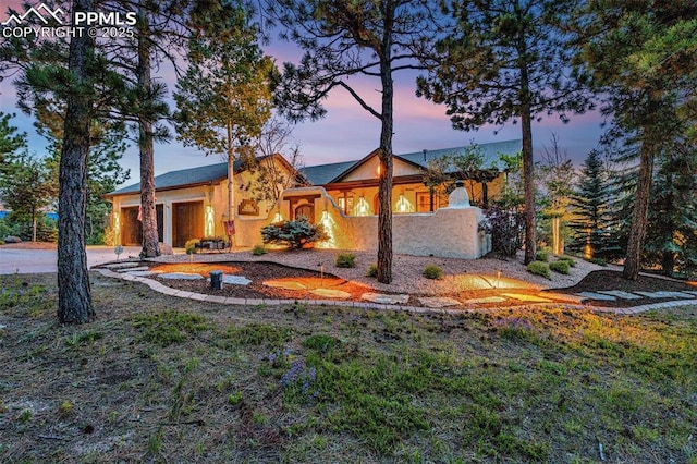 17995 Minglewood Trl, Monument, CO 80132 - back of house with stucco siding, an attached garage, and concrete driveway